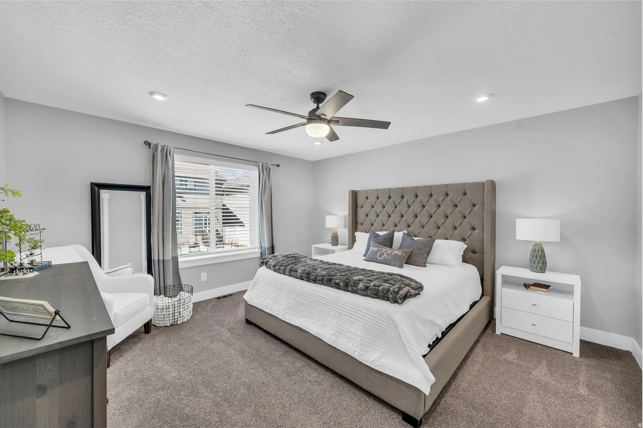 Bedroom with dark colored carpet, ceiling fan, recessed lighting, and a textured ceiling