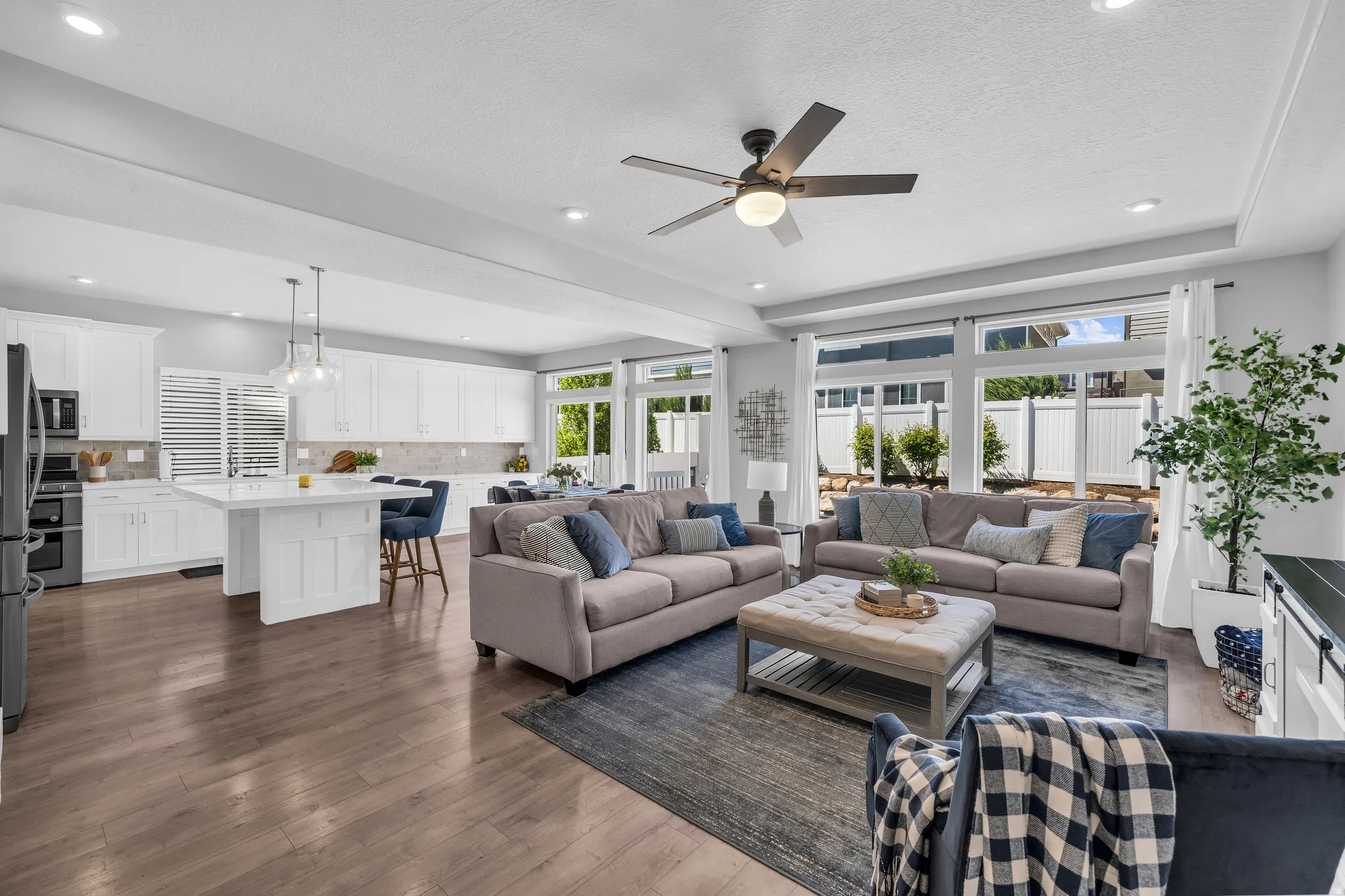 Living area featuring a ceiling fan, dark wood-type flooring, recessed lighting, and a textured ceiling