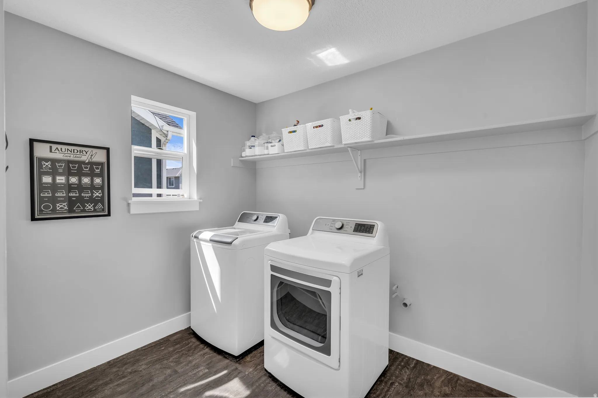 Laundry room featuring washer and dryer and dark wood finished floors