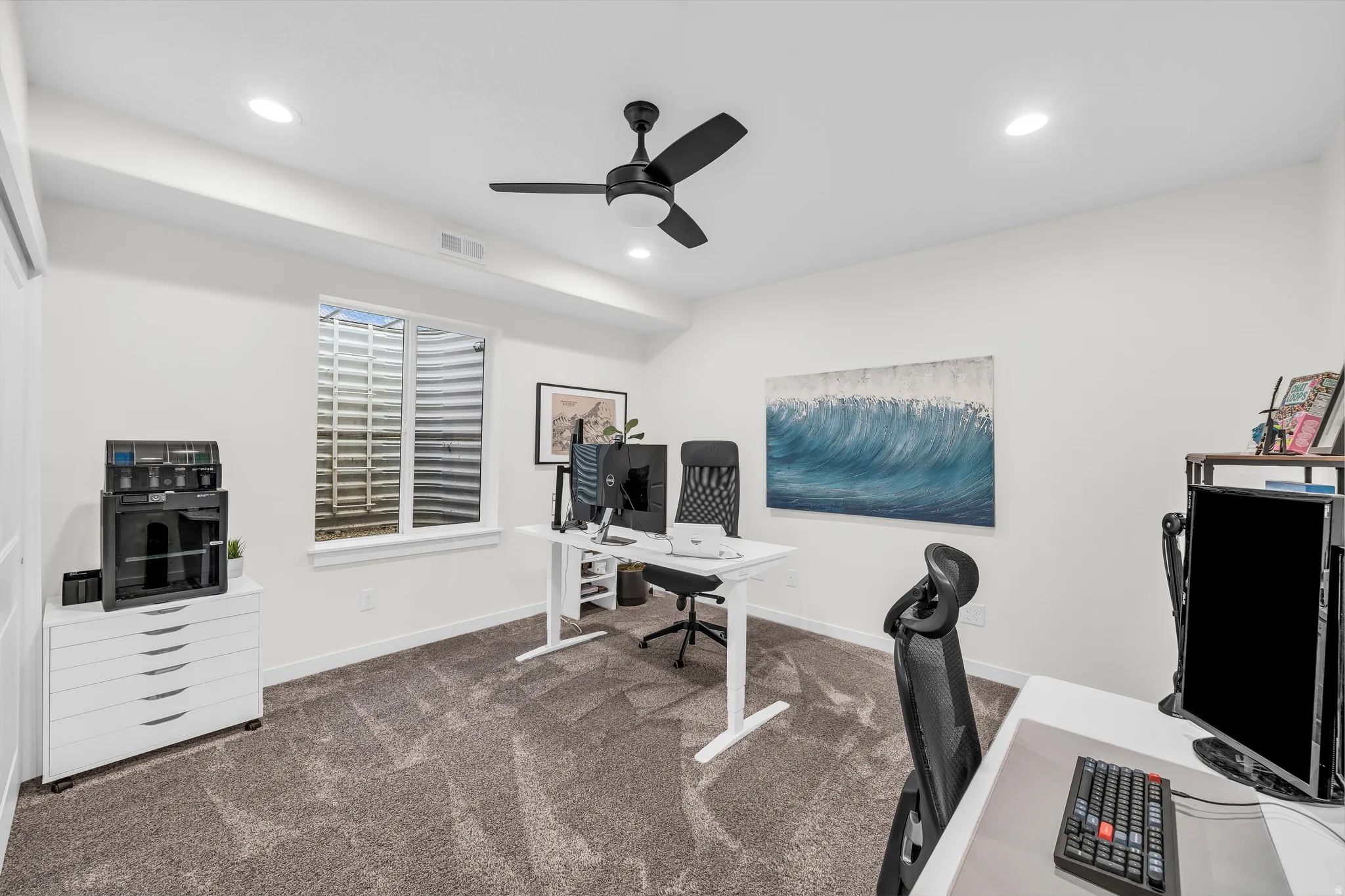 Home office featuring dark colored carpet, ceiling fan, and recessed lighting