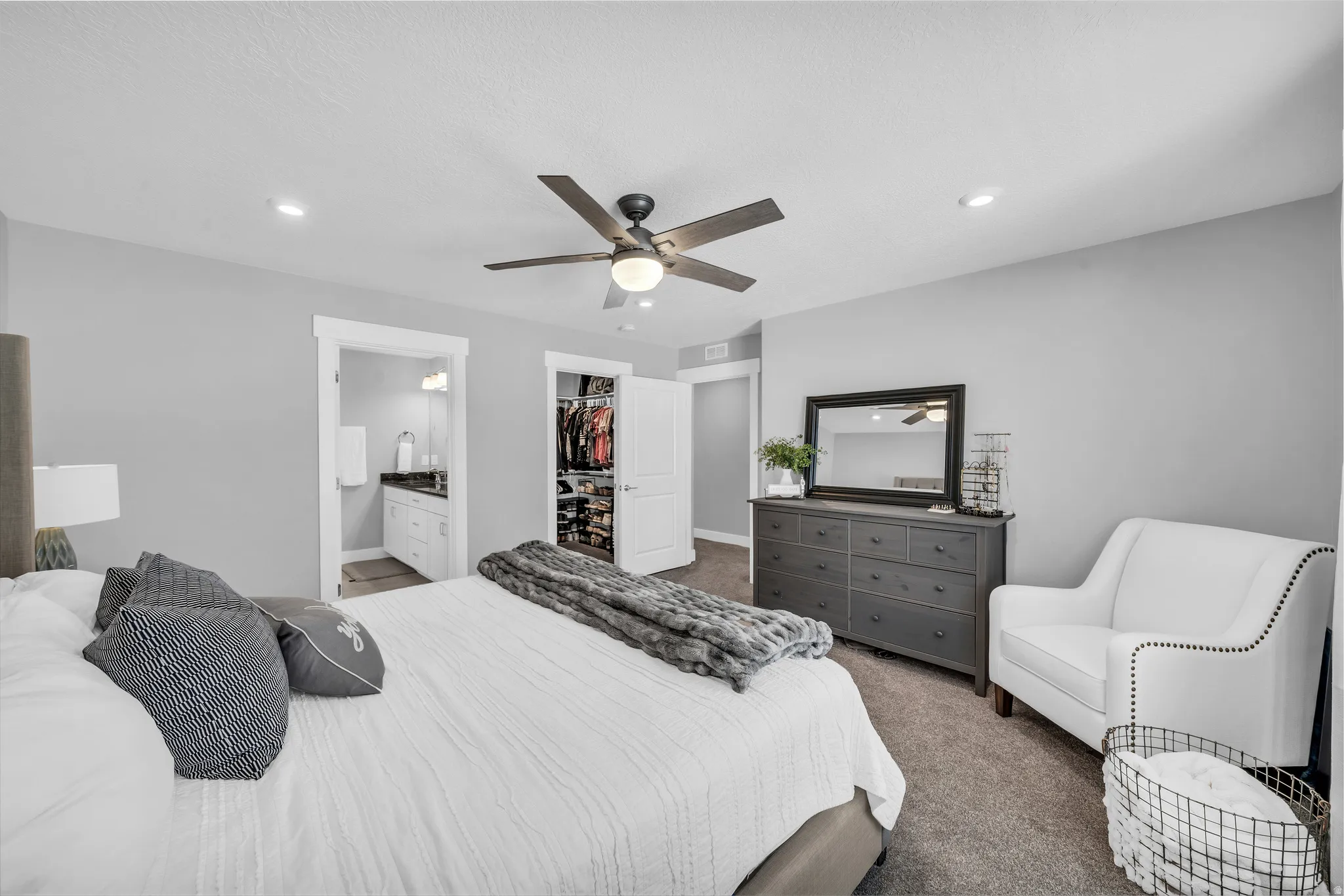 Bedroom featuring dark colored carpet, a spacious closet, ceiling fan, recessed lighting, and ensuite bathroom