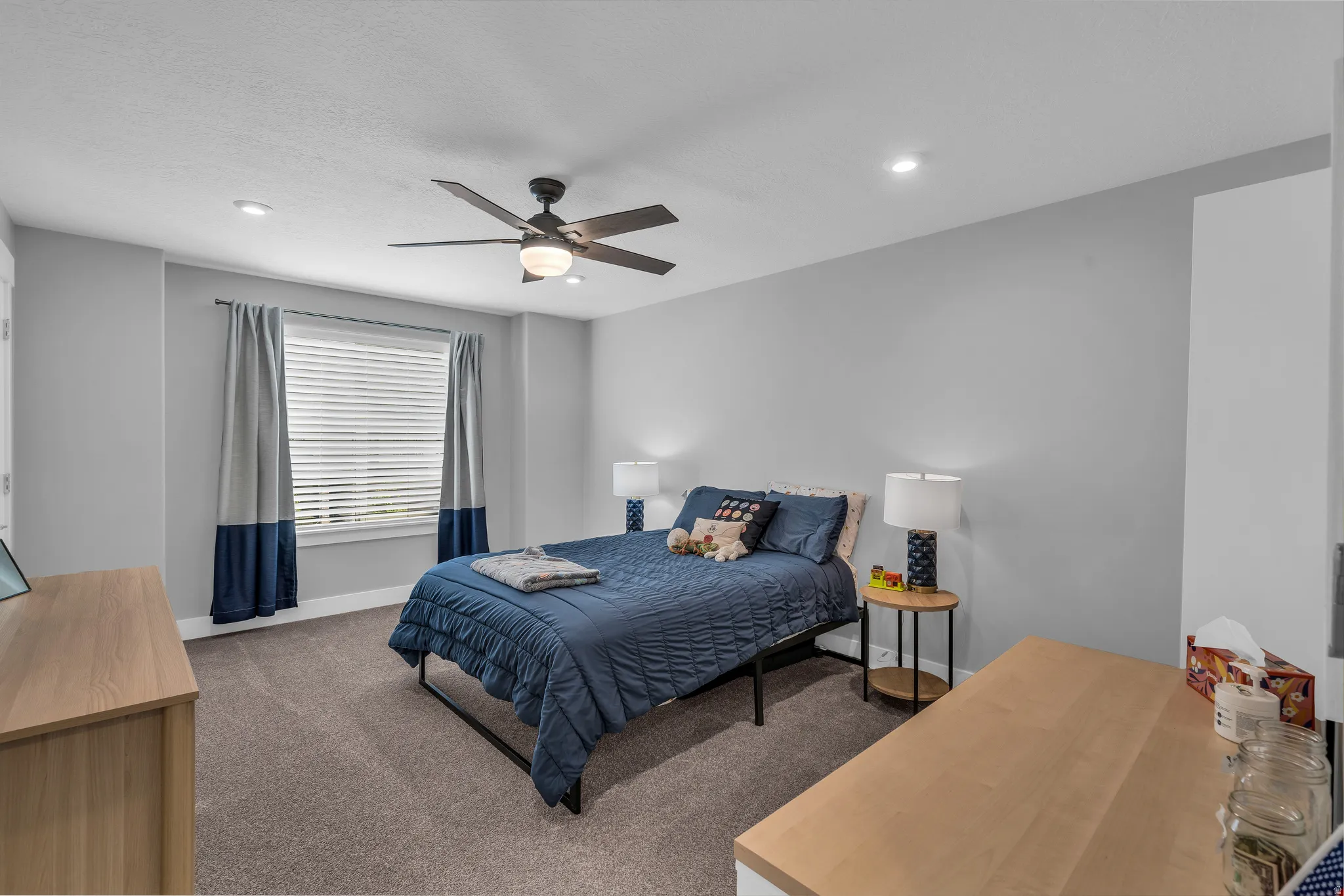 Carpeted bedroom with ceiling fan and recessed lighting