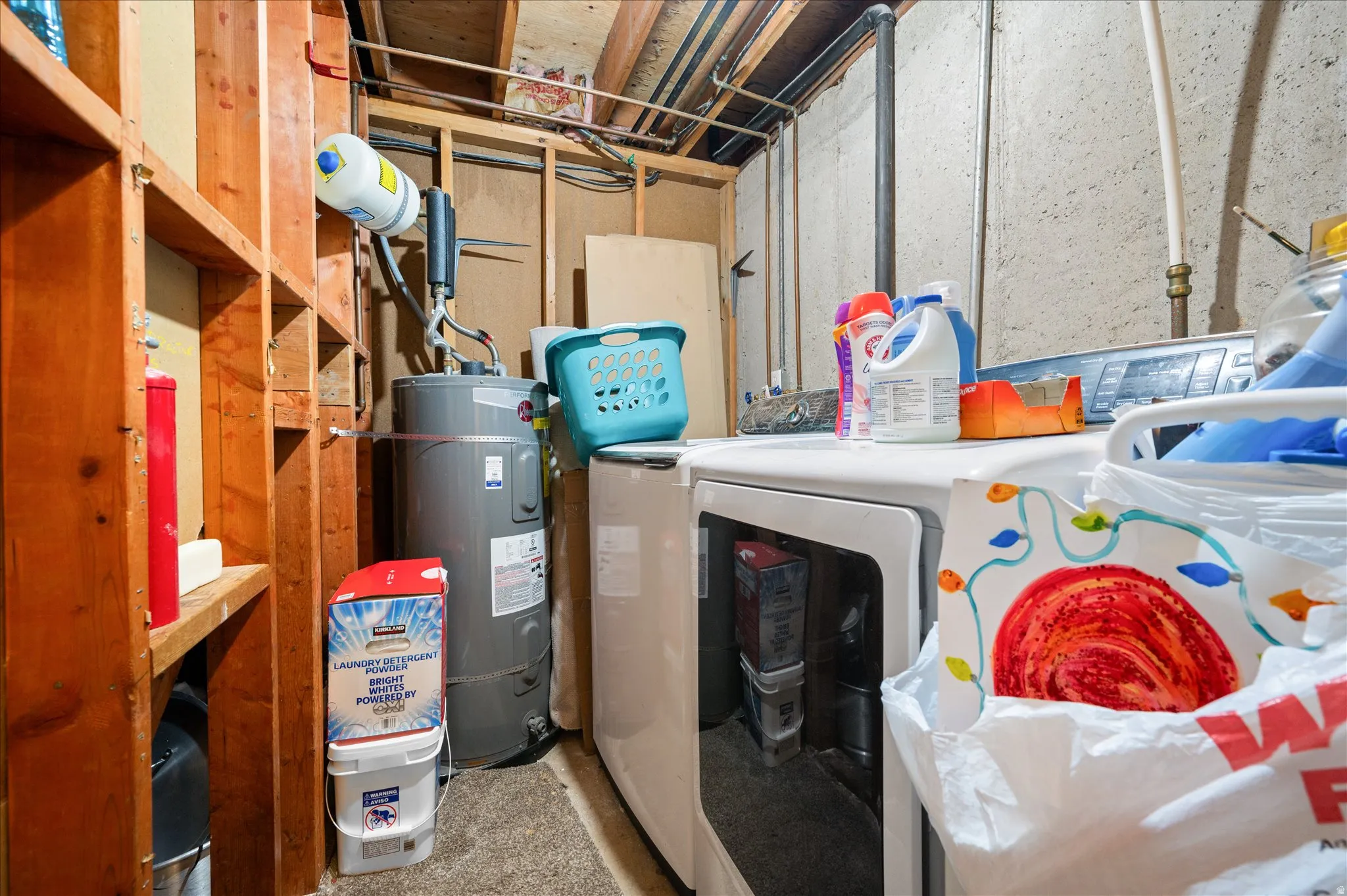 Laundry area featuring separate washer and dryer, electric water heater, and concrete floors