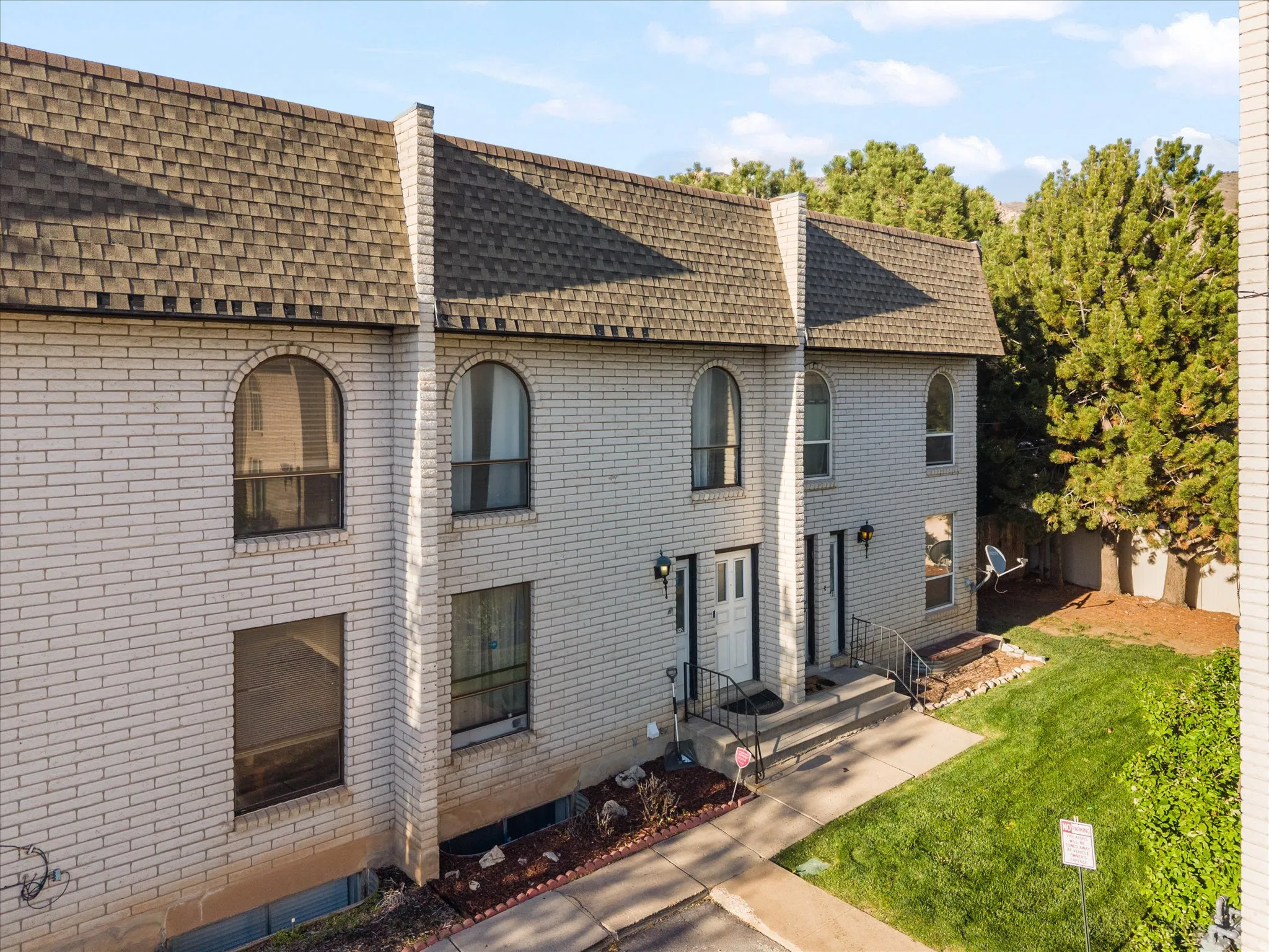 View of front of property with brick siding, a shingled roof, and a front lawn