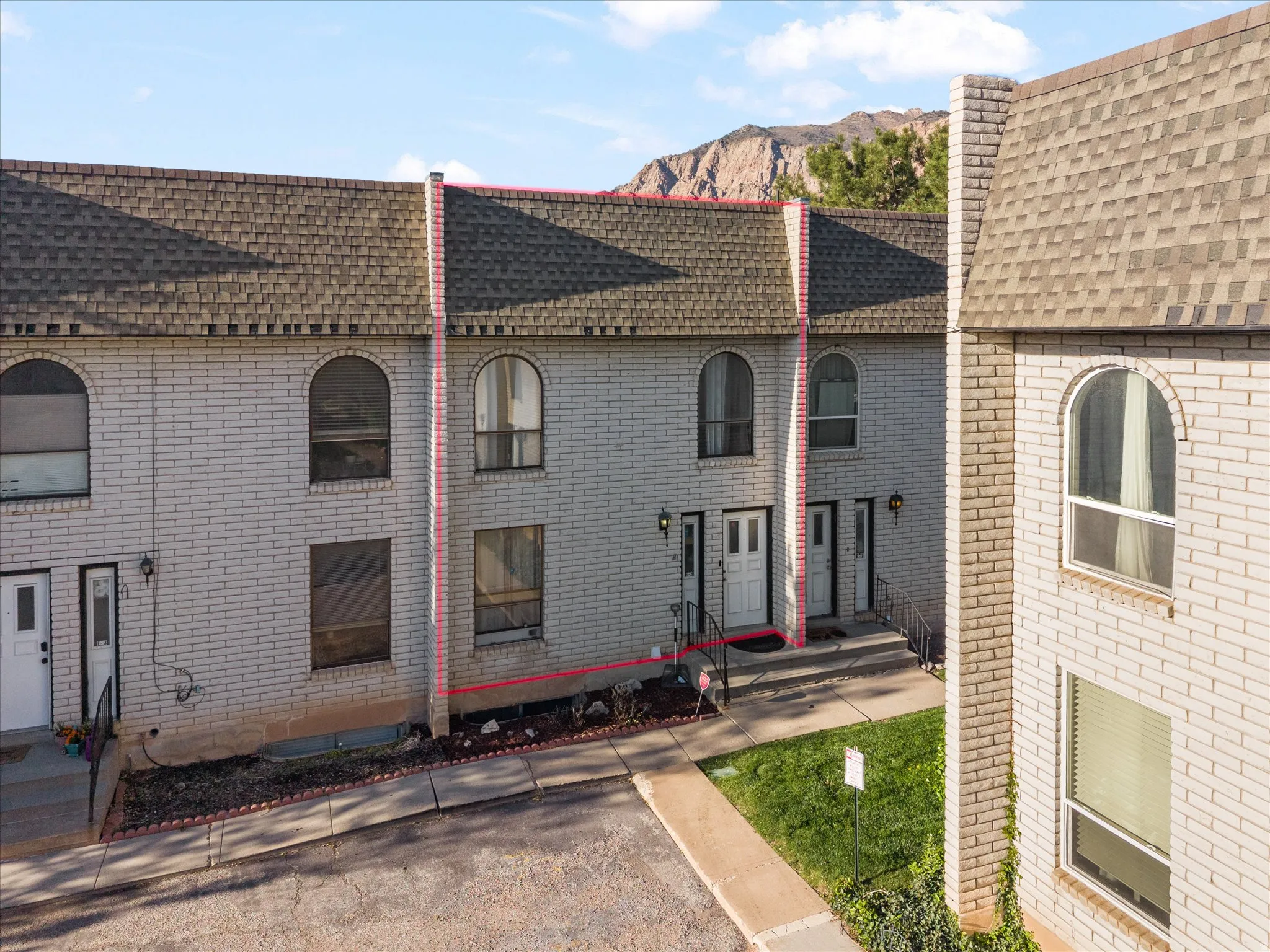 View of front of house with brick siding, a shingled roof, and a mountain view