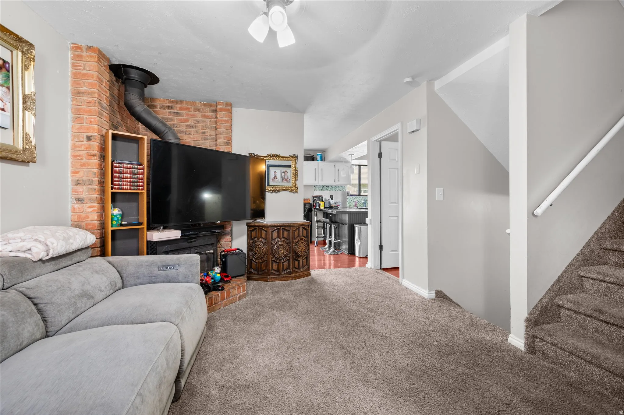 Living room featuring light colored carpet and stairs