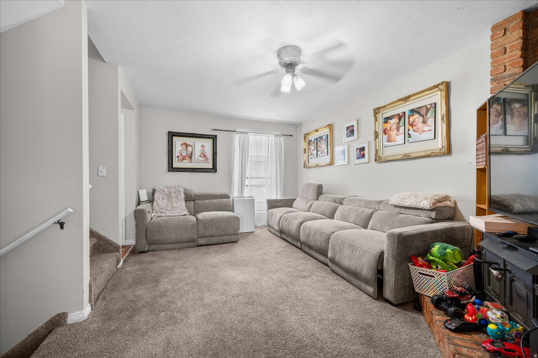Living area with a ceiling fan and carpet