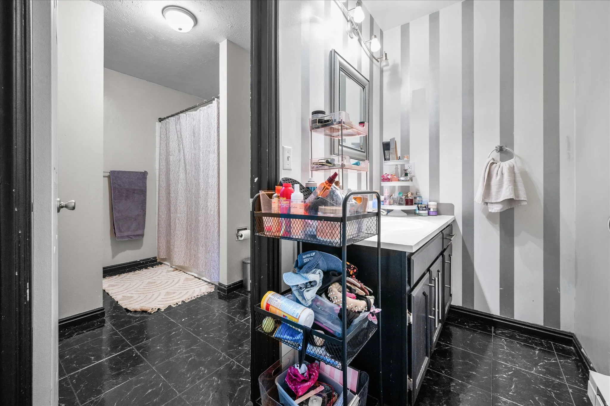 Bathroom featuring vanity, a shower with curtain, and wallpapered walls