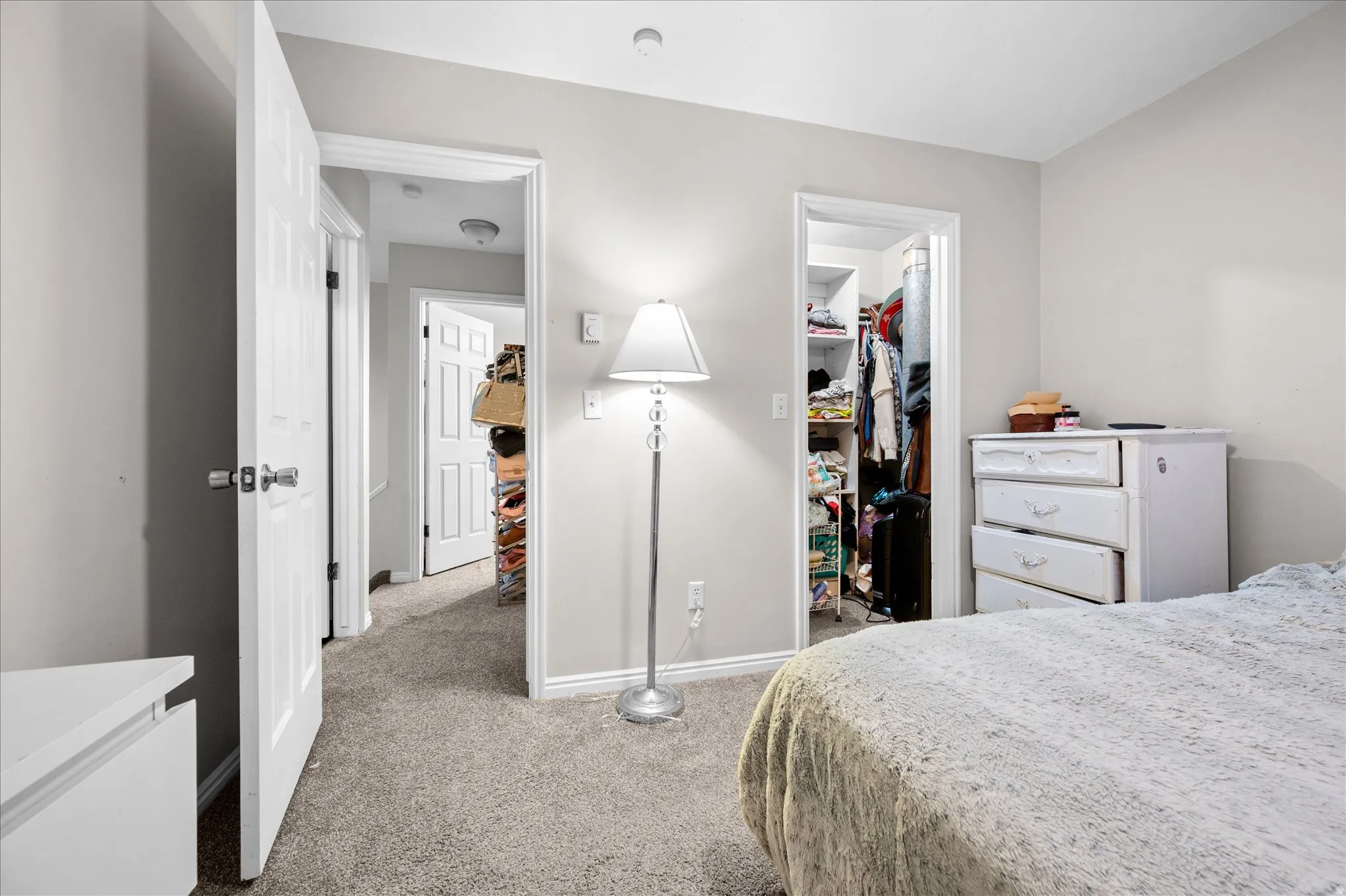 Bedroom featuring light carpet and a spacious closet