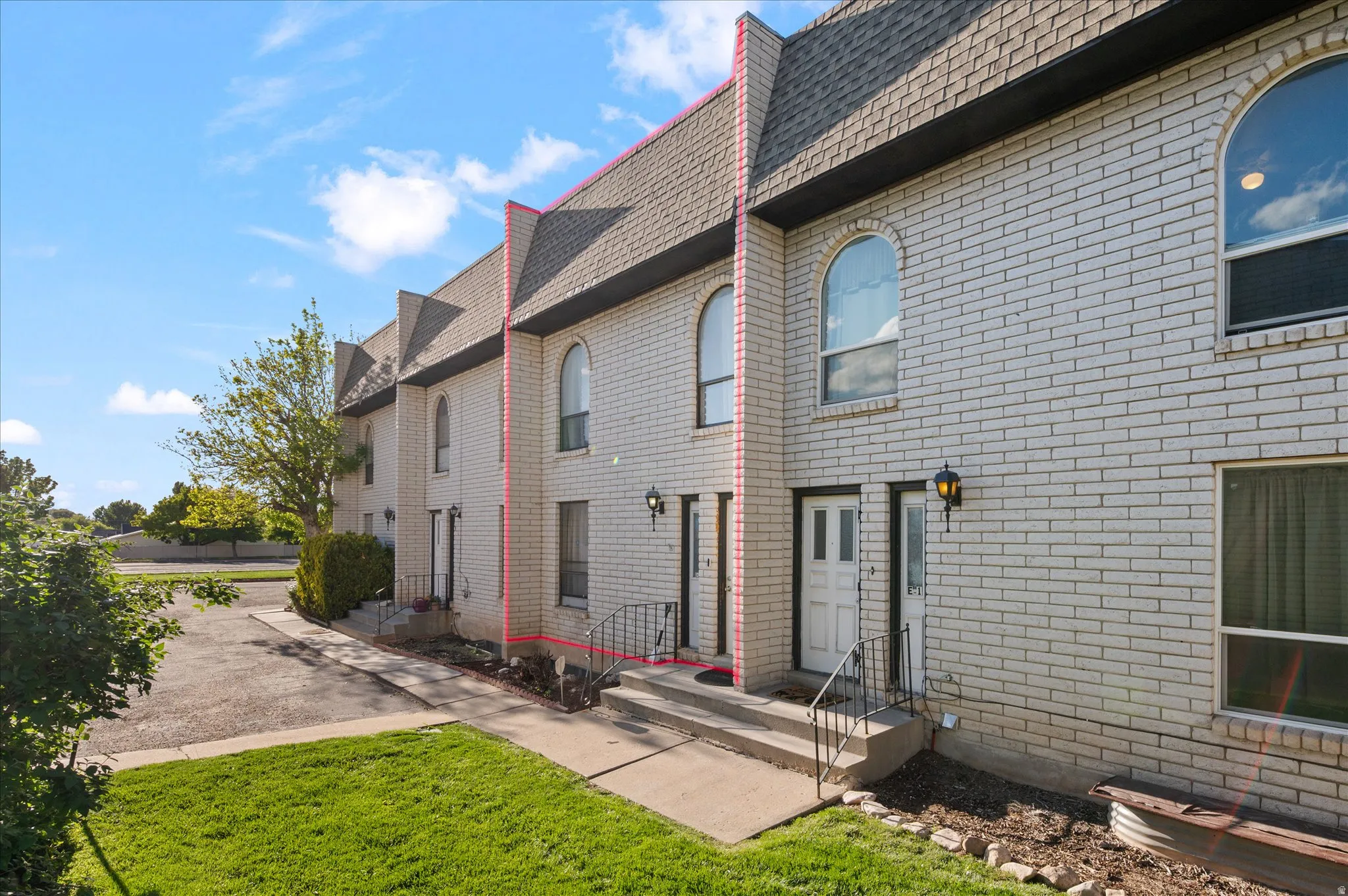 Rear view of house with a yard, brick siding, and roof with shingles