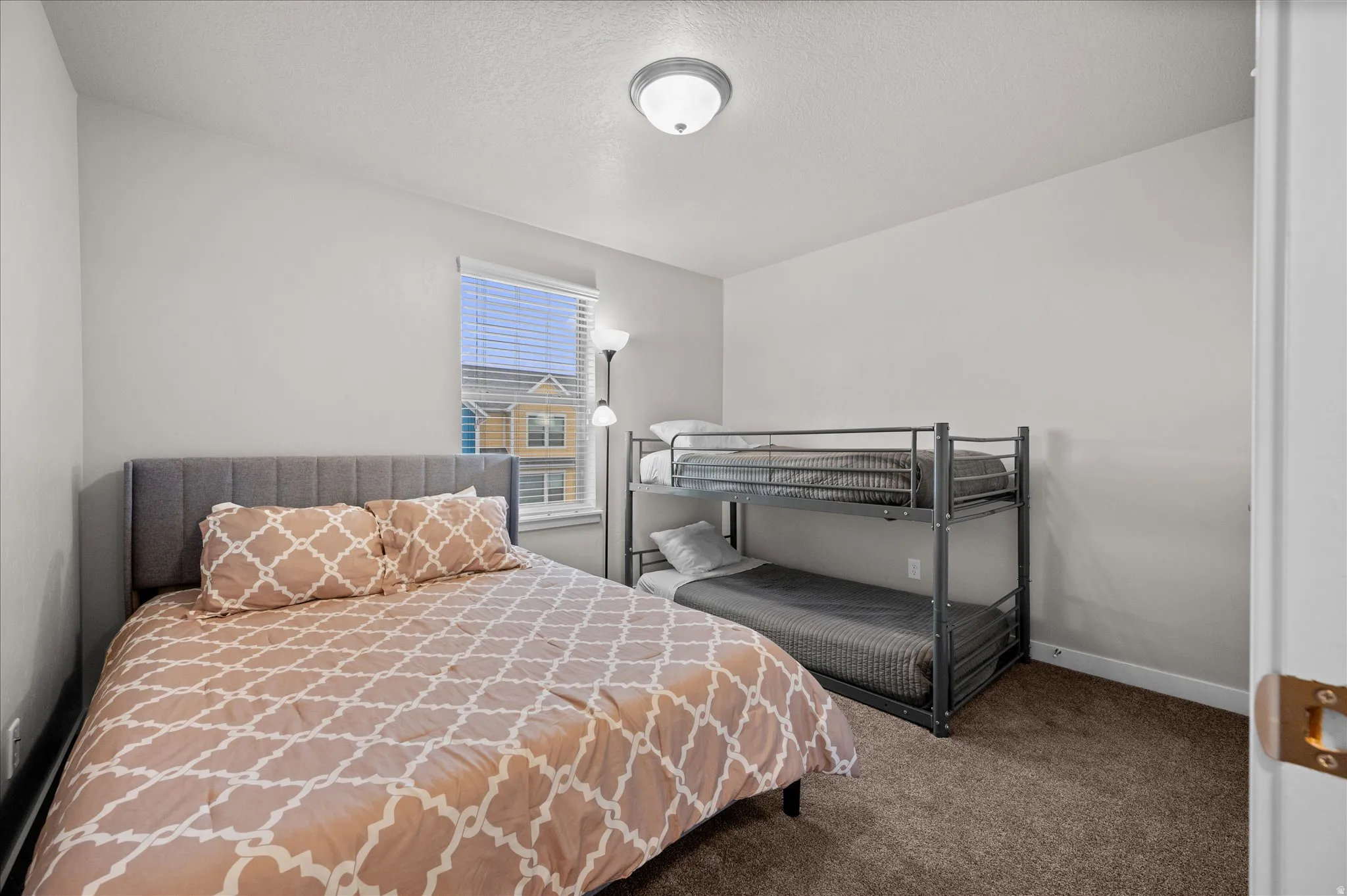 Bedroom featuring carpet and a textured ceiling