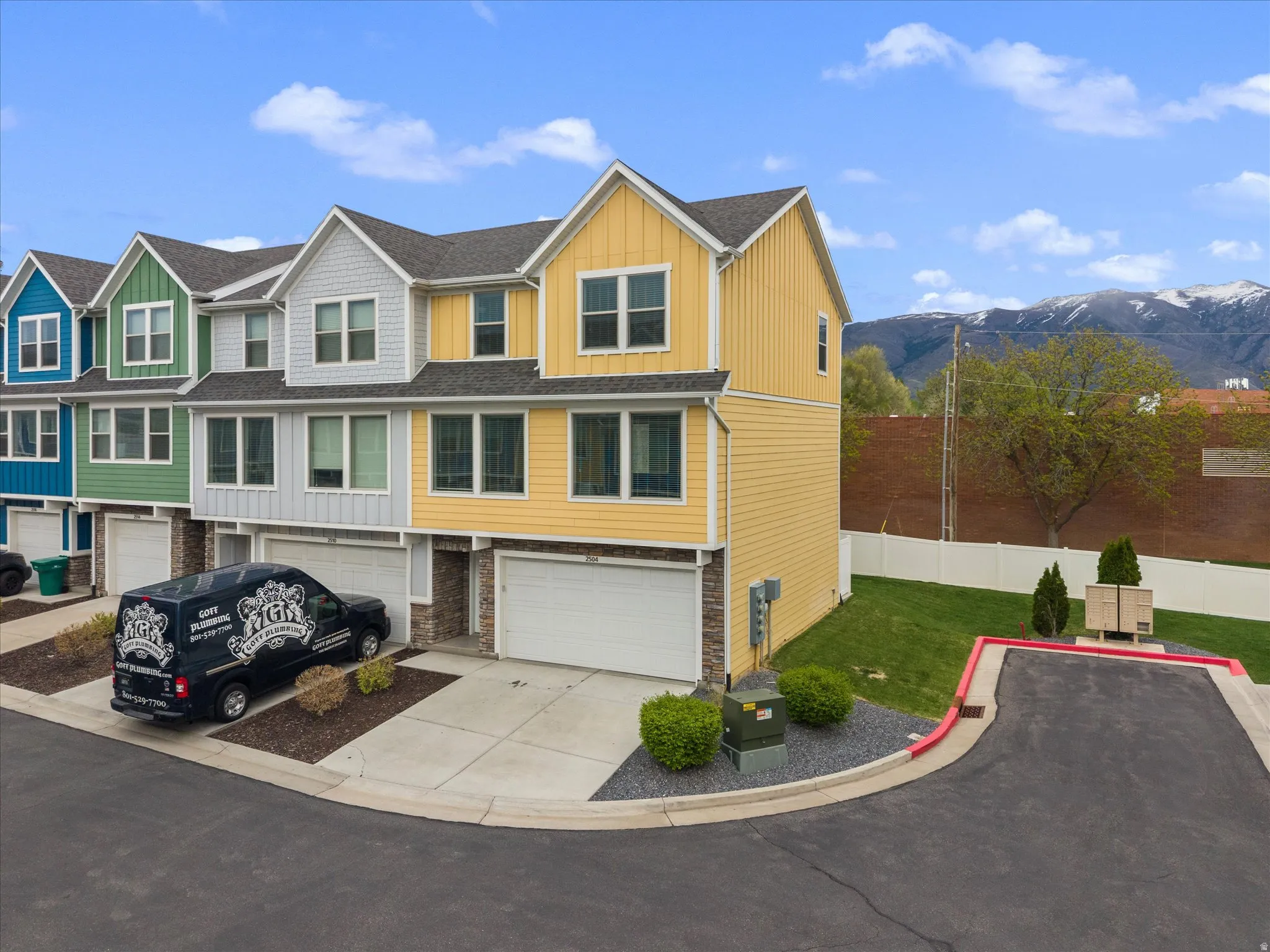 View of front of home with board and batten siding, concrete driveway, a garage, a mountain view, and a residential view