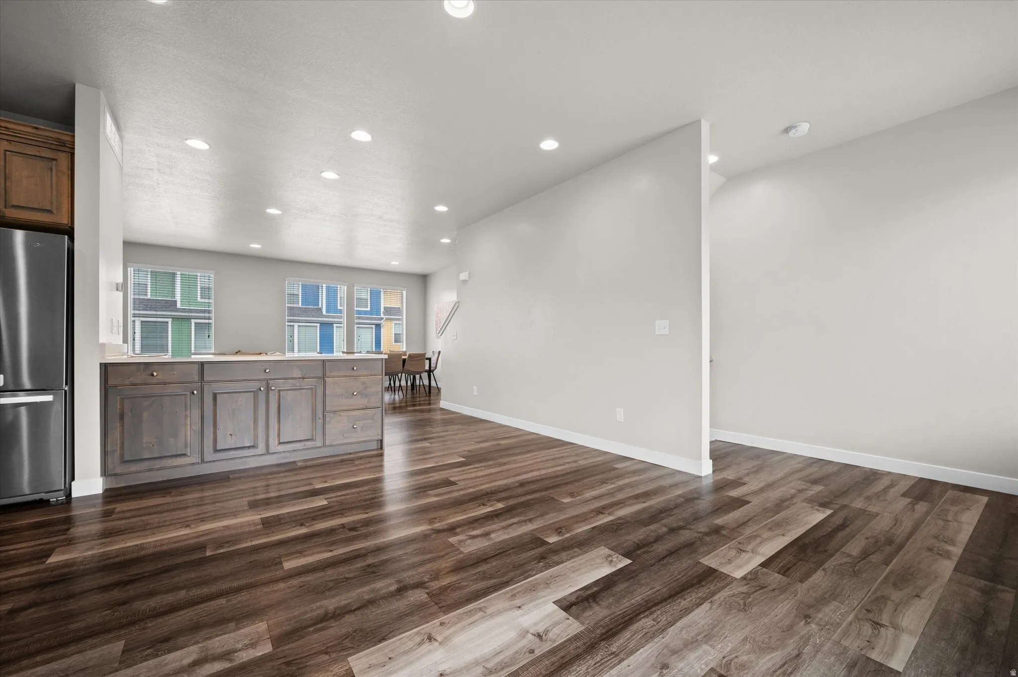 Unfurnished living room with recessed lighting and dark wood-style floors