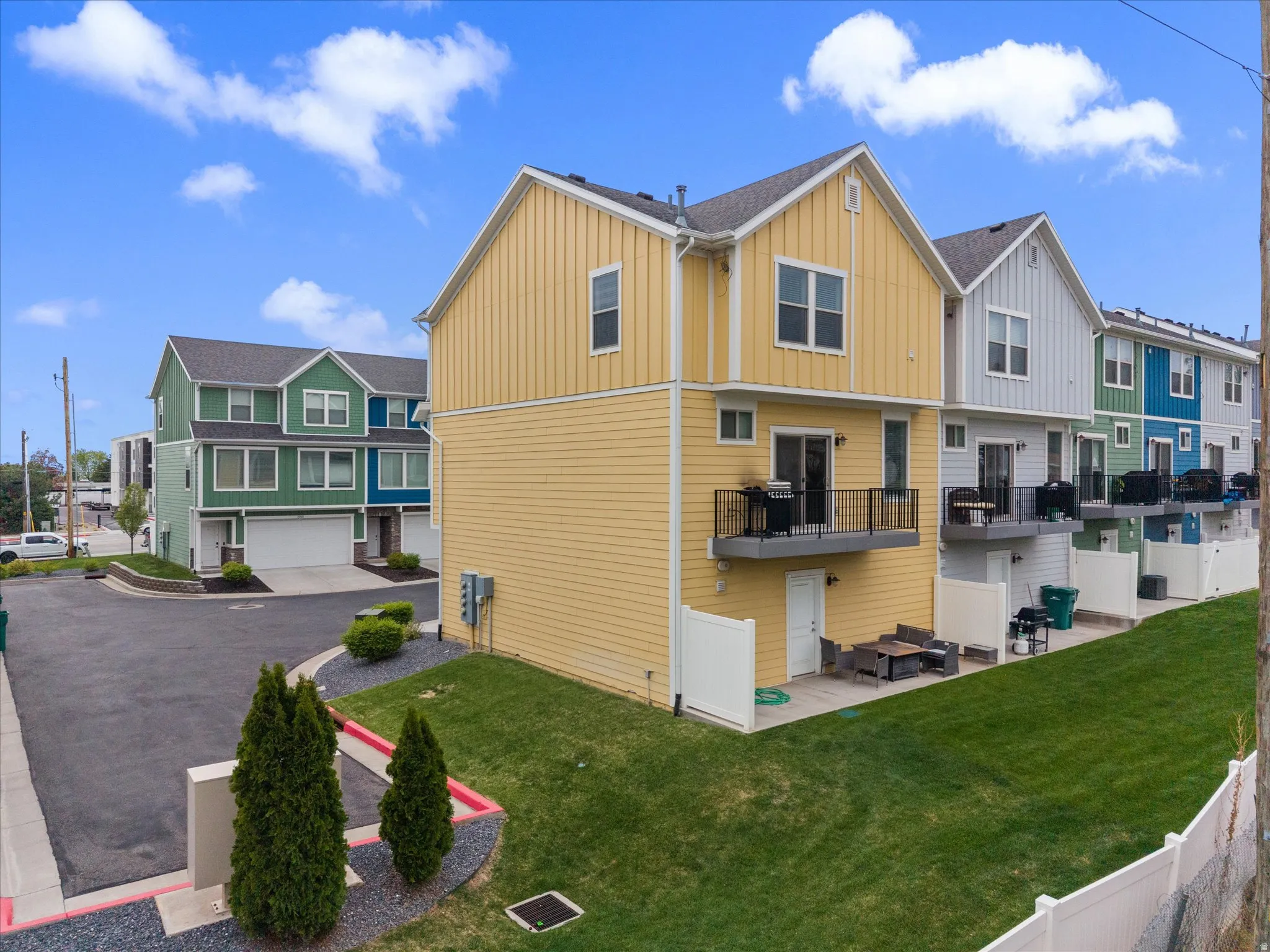 Rear view of property with a residential view, board and batten siding, a patio area, and a balcony