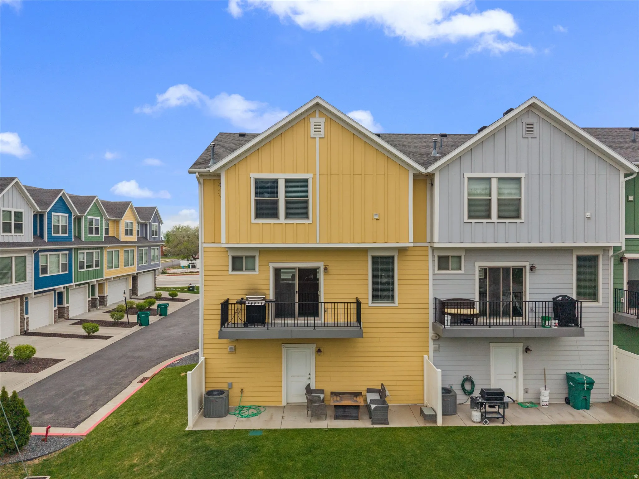 Back of property featuring a patio, board and batten siding, a residential view, and a lawn