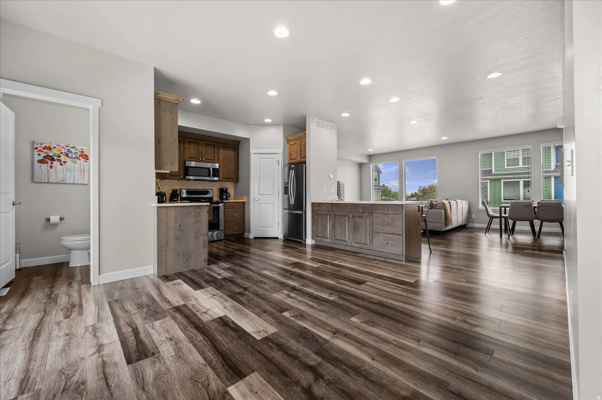 Kitchen with open floor plan, stainless steel appliances, light countertops, a peninsula, and recessed lighting