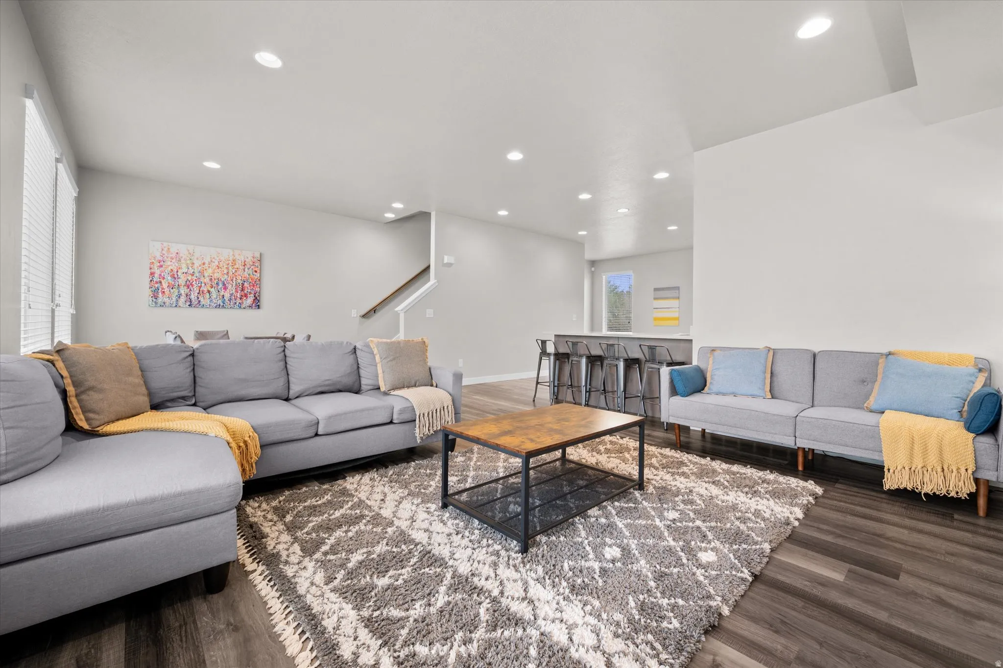Living area with dark wood-style flooring and recessed lighting