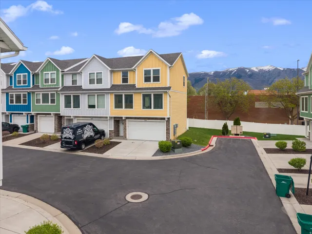 View of front of home featuring a residential view, a garage, board and batten siding, concrete driveway, and a mountain view