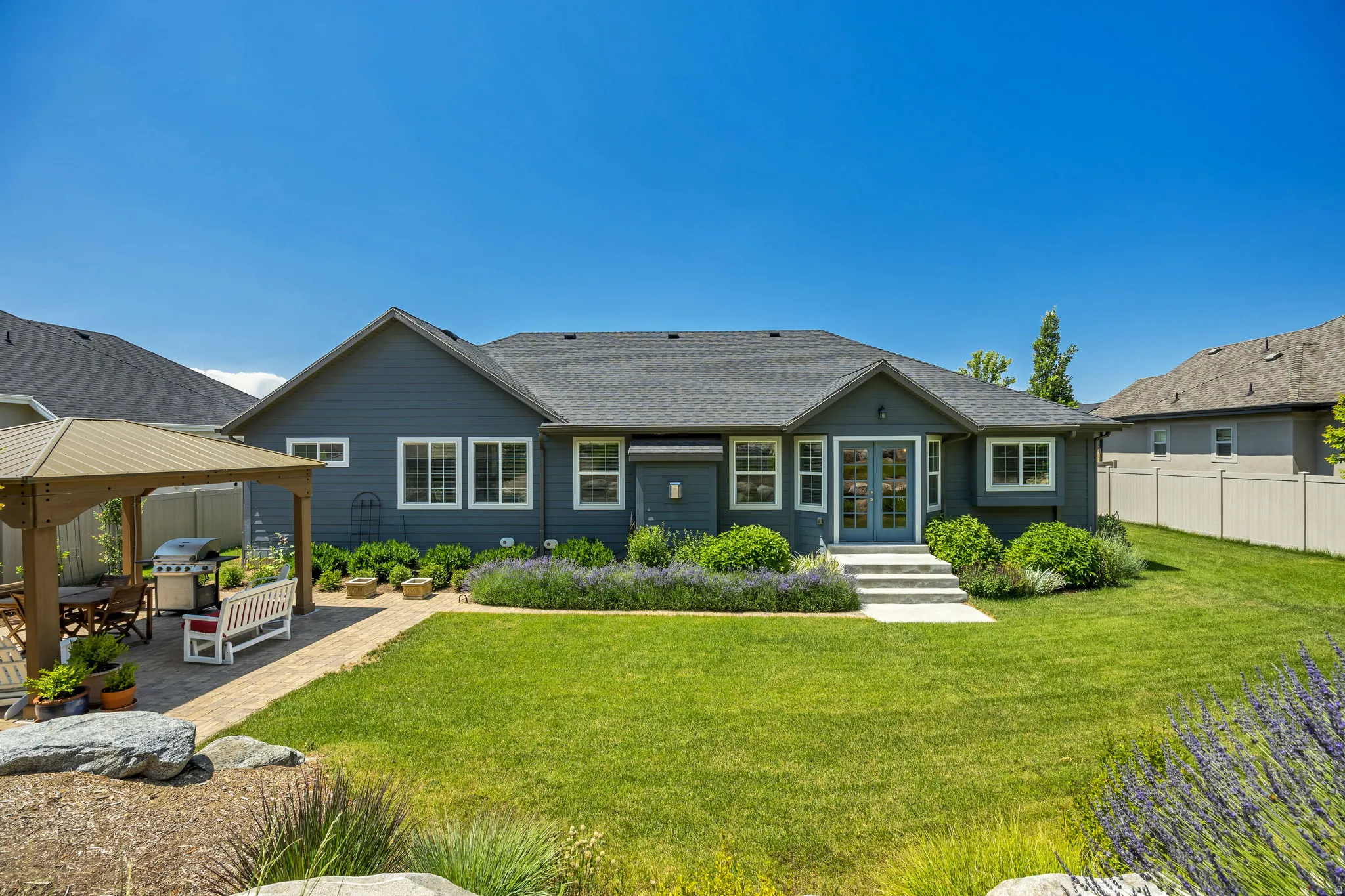 Rear view of house featuring french doors, a gazebo, and a shingled roof