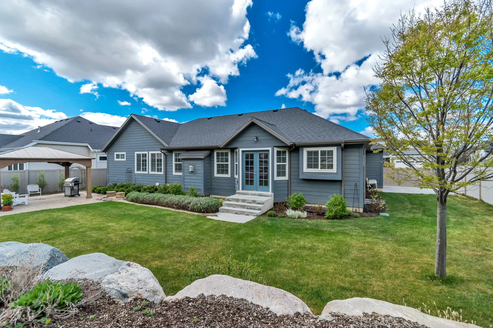 View of front facade with french doors, roof with shingles, a patio area, a gazebo, and entry steps