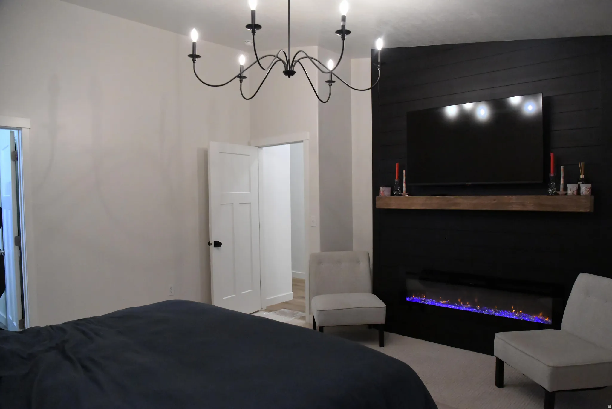 Primary bedroom featuring a glass covered fireplace and hanging lights