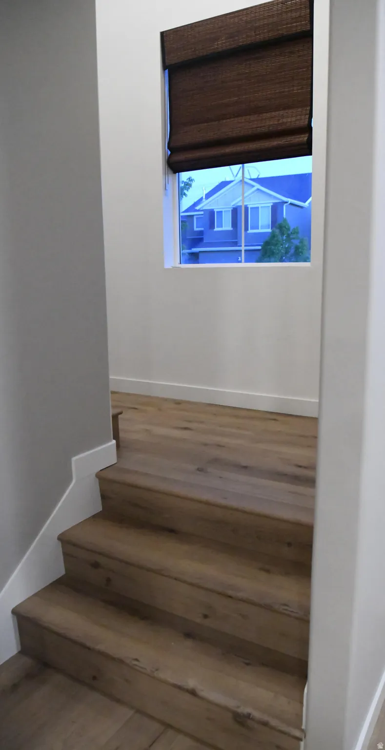 Stairway featuring hardwood / wood-style floors and baseboards
