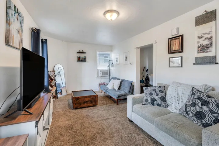 Carpeted living room with cooling unit.
