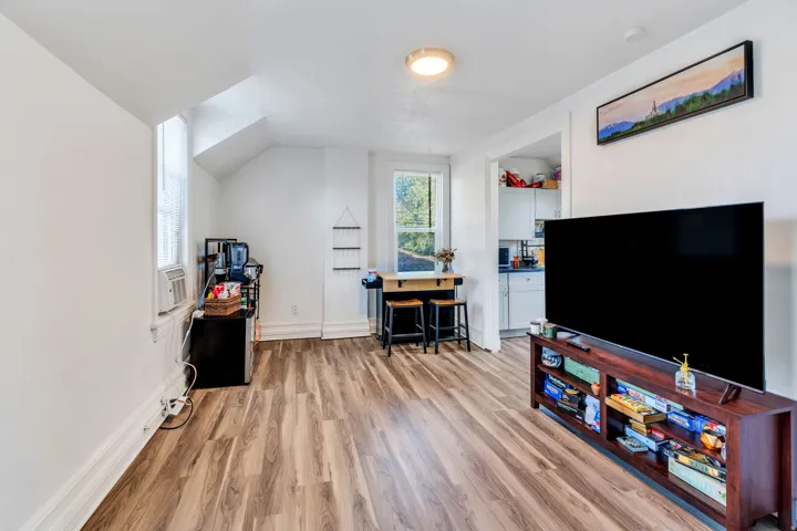 Office space featuring light wood-type flooring, vaulted ceiling.