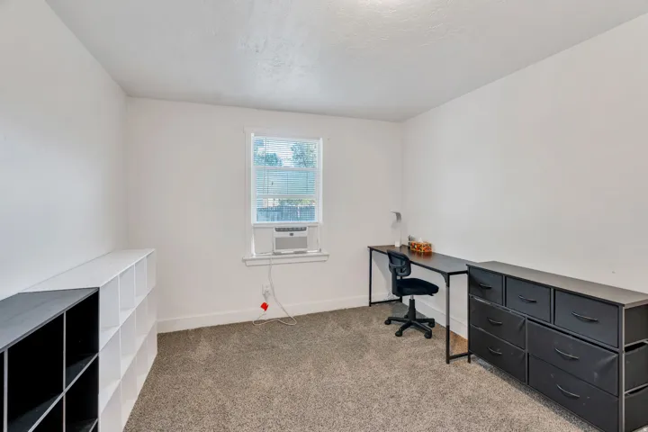 Office area with light carpet and a textured ceiling.