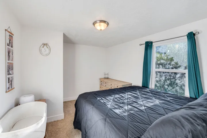 Carpeted bedroom with baseboards and a textured ceiling.