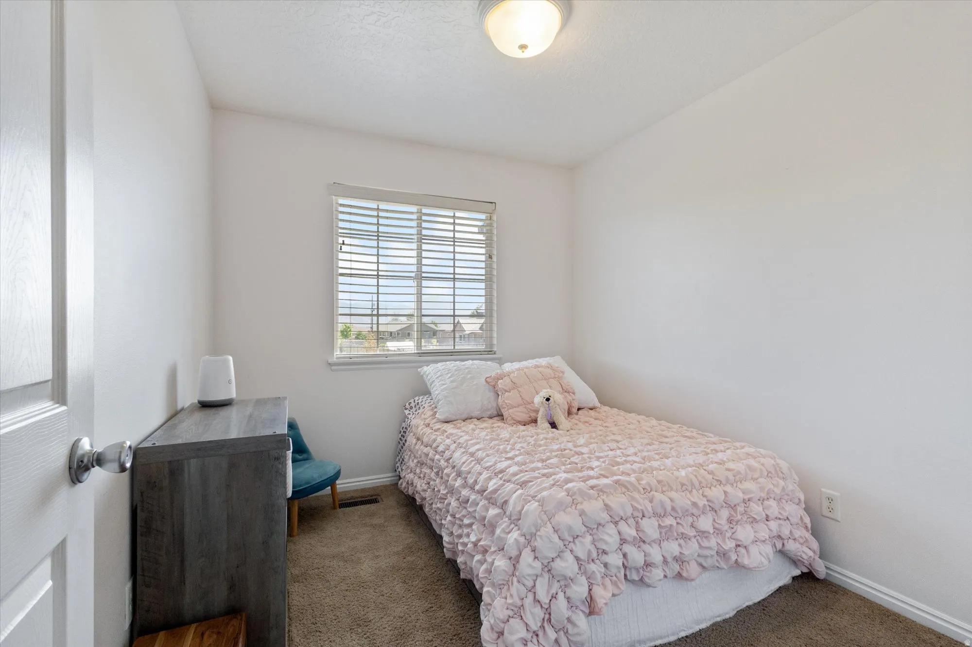 Bedroom with dark colored carpet and baseboards