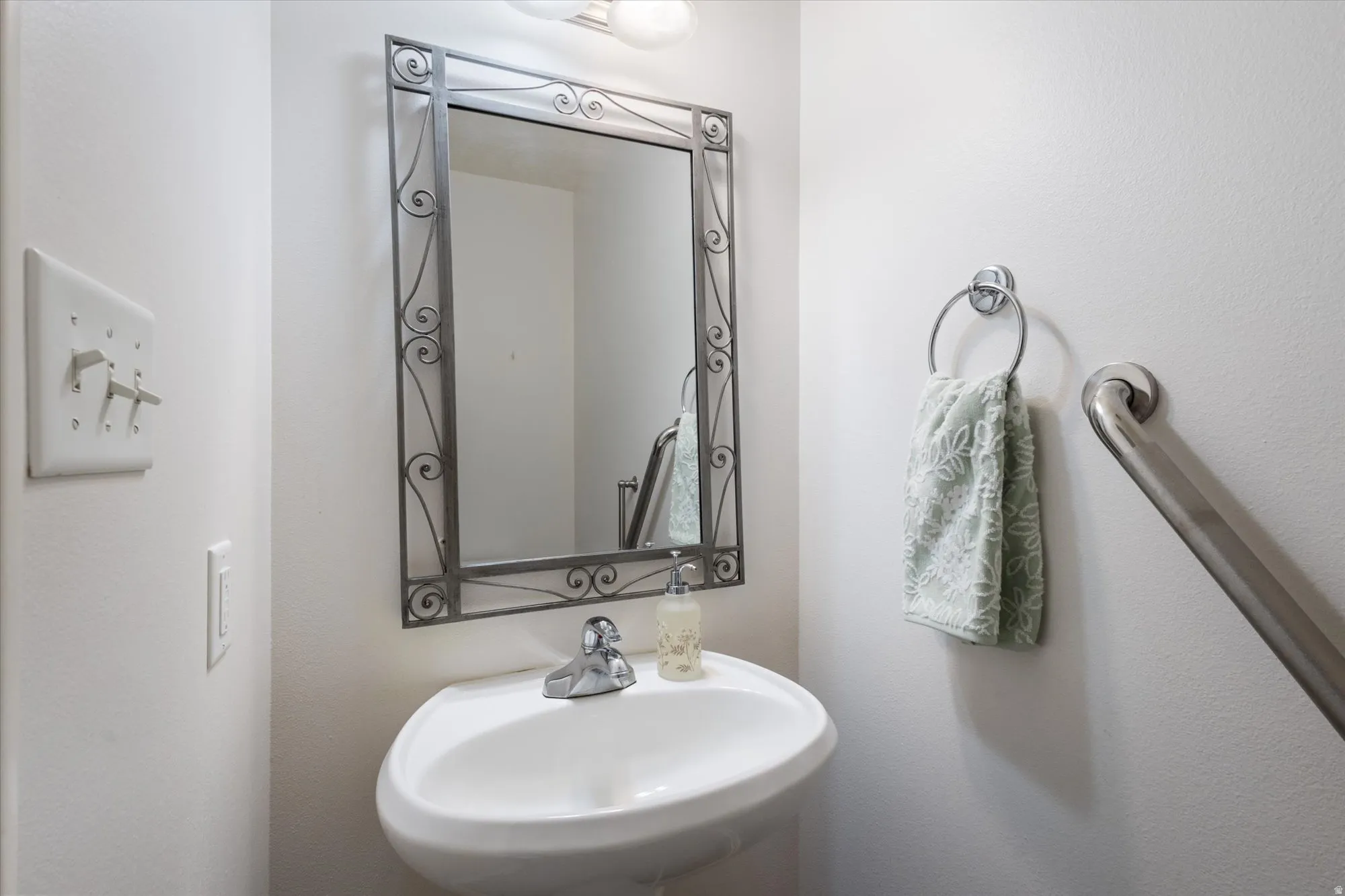 Bathroom featuring a sink and a textured wall