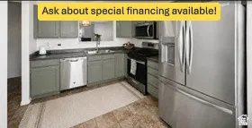 Kitchen featuring sage-toned cabinetry, dark countertops, and stainless steel appliances including a refrigerator, range, microwave, and dishwasher