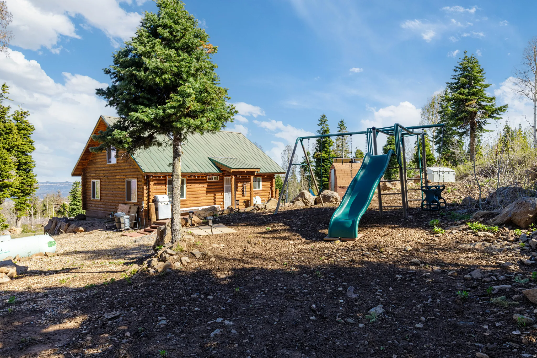 Backyard Play Area: Includes a children's playset tucked away in the trees.