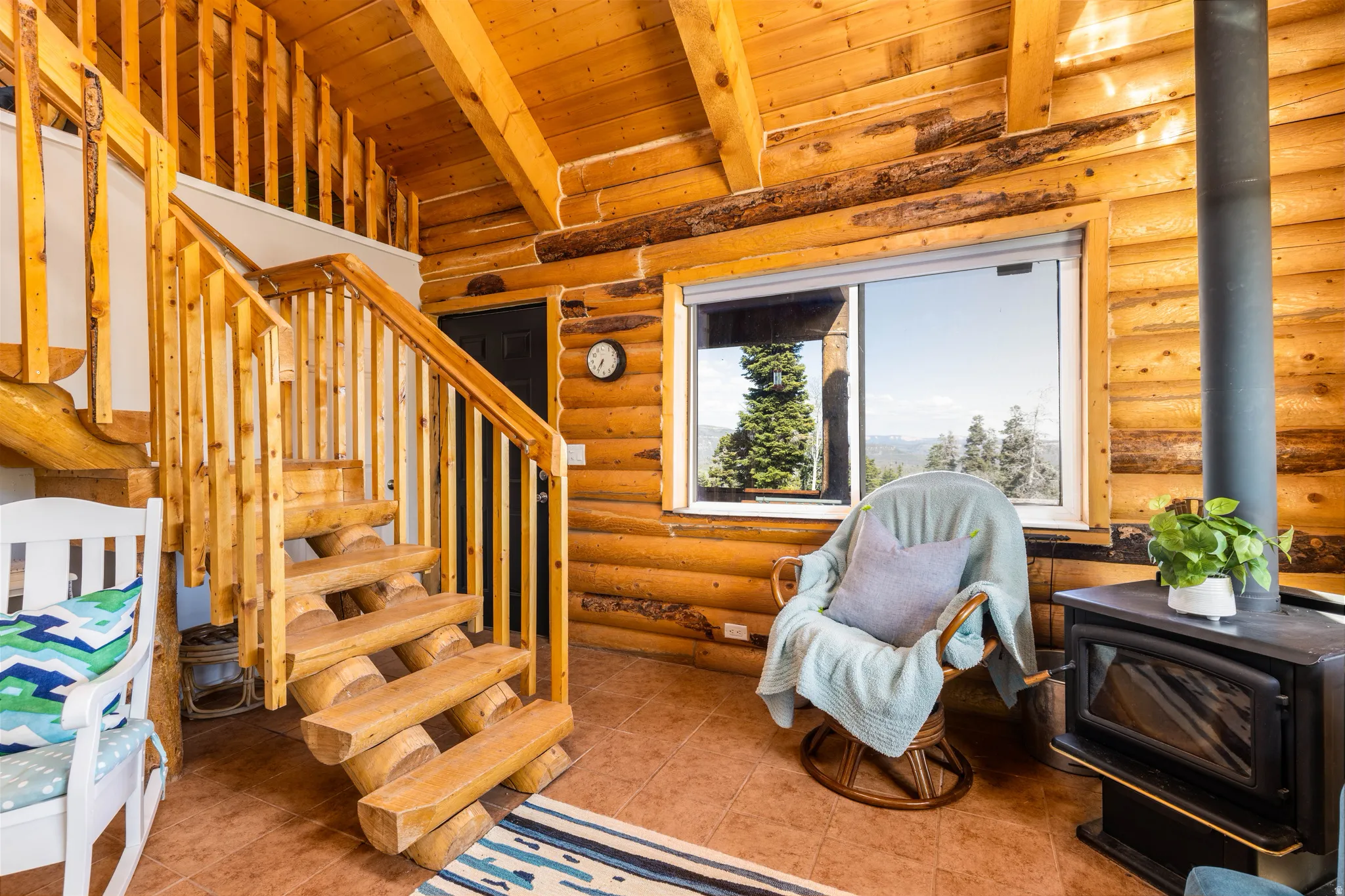 Entry & Living Room Nook: A cozy reception area featuring a wood-burning stove and rustic staircase.