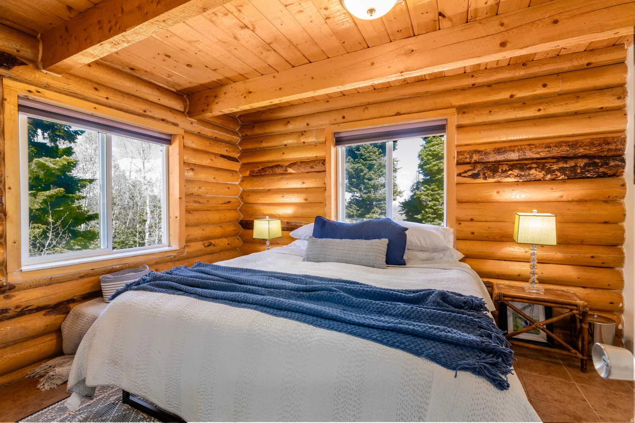 Primary Bedroom: Main floor bedroom featuring authentic log walls and large windows.