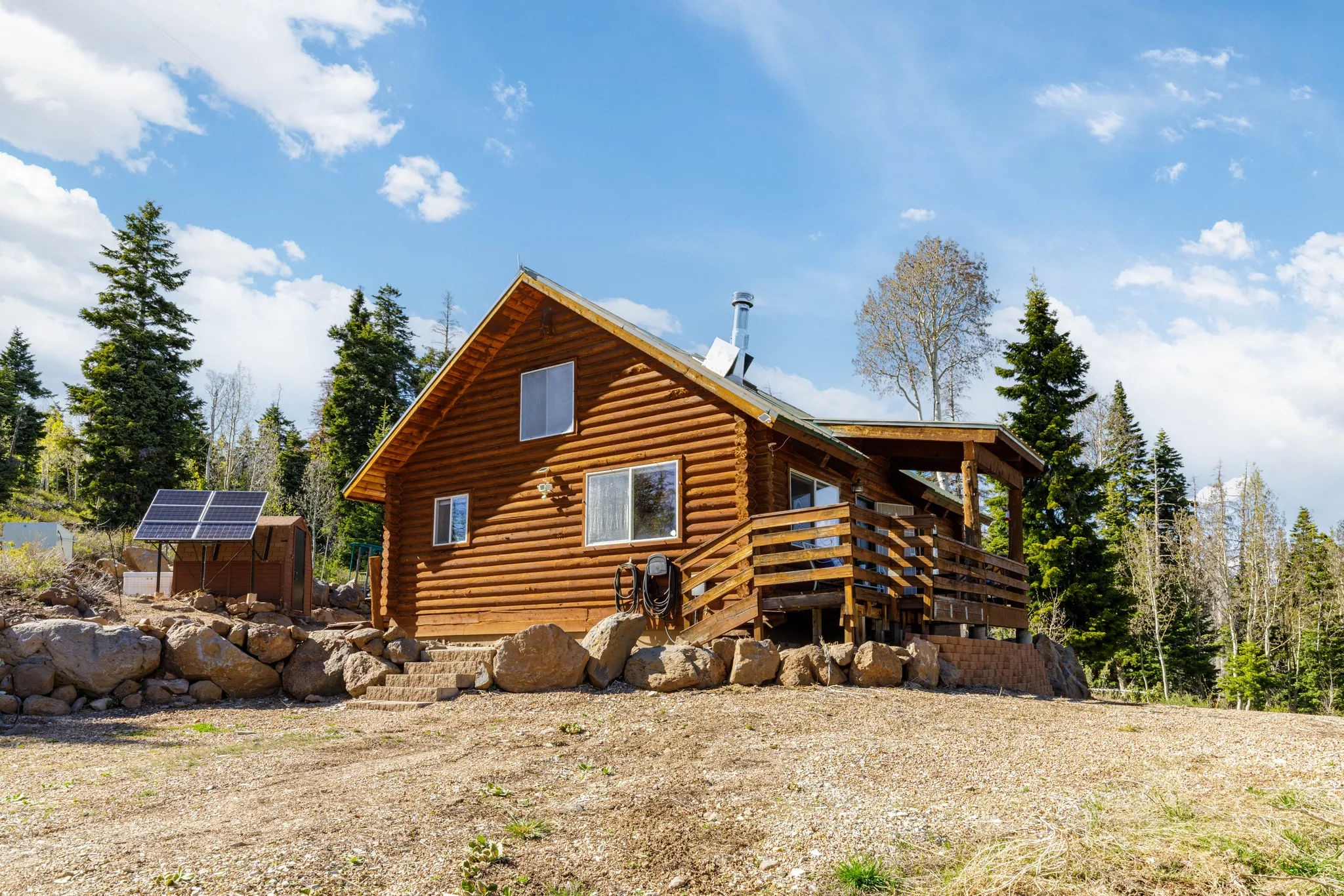 Classic Log Cabin Exterior: Authentic log construction nestled perfectly into the high-altitude mountain landscape.