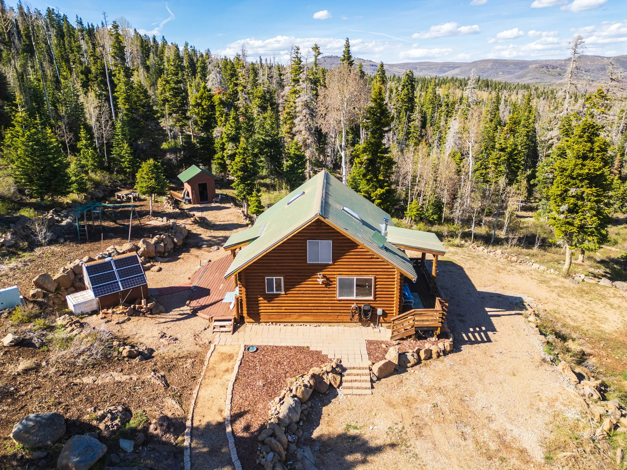 Aerial Property Overview: Bird’s-eye view showing the cabin layout and the surrounding forest.