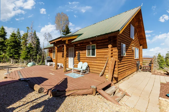 Expansive Back Deck: Large wooden deck perfect for outdoor dining and forest views.
