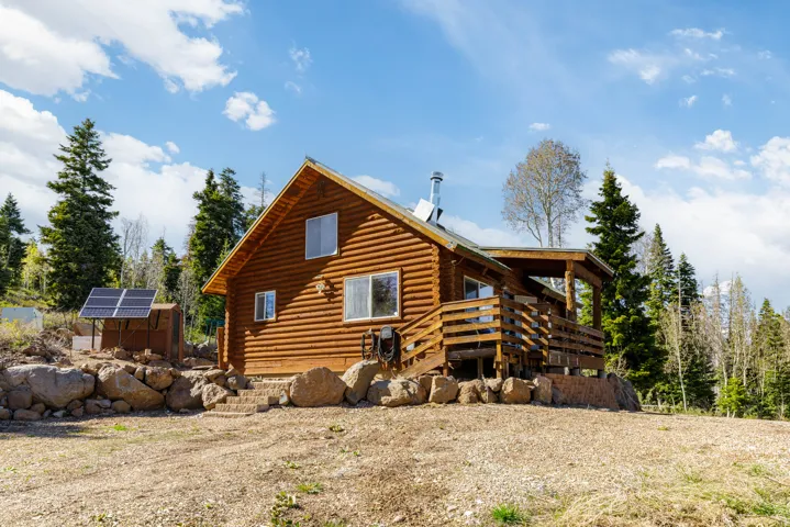 Classic Log Cabin Exterior: Authentic log construction nestled perfectly into the high-altitude mountain landscape.
