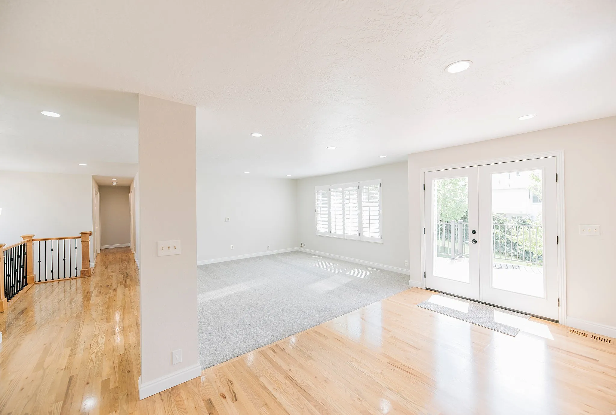 Entryway with french doors, wood finished floors, recessed lighting, and carpet
