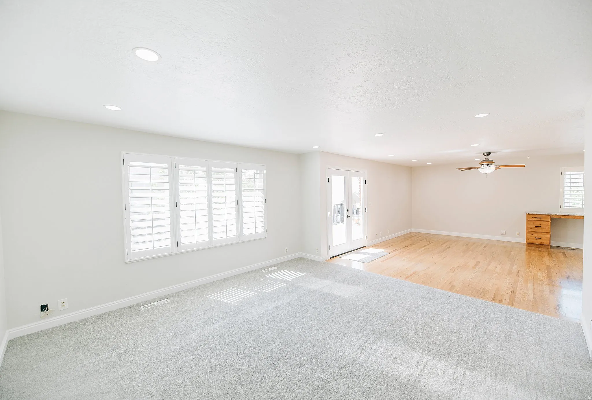 Unfurnished living room with french doors, light carpet, plenty of natural light, recessed lighting, and a ceiling fan