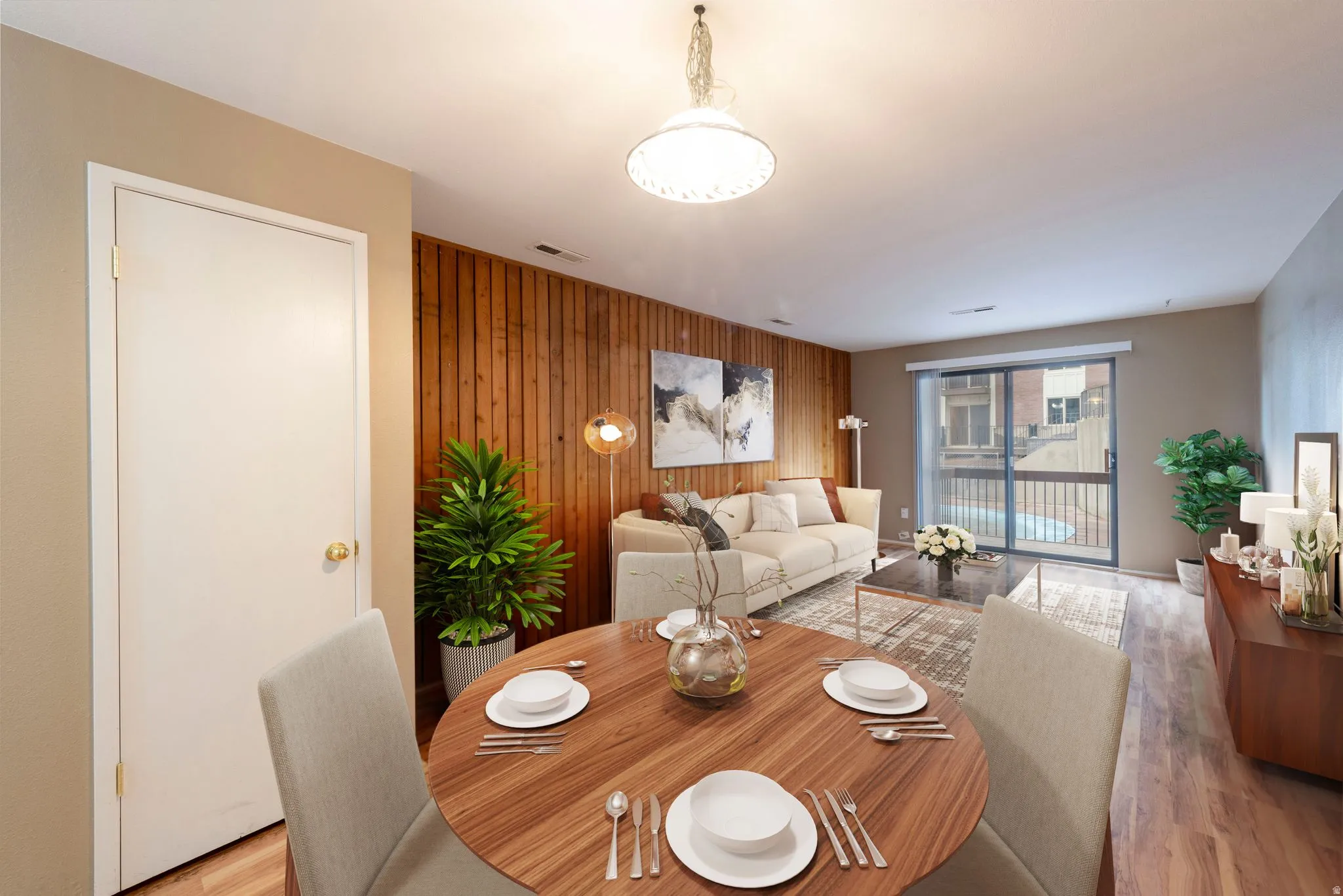 Dining area featuring wooden accent wall, light wood-style flooring.