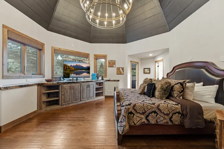 Bedroom featuring a chandelier and dark wood-type flooring