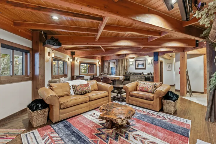 Living room with a wooden ceiling with exposed beams and wood finished floors