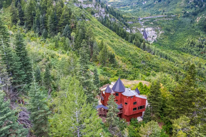 Aerial view of property and surrounding area featuring a forest