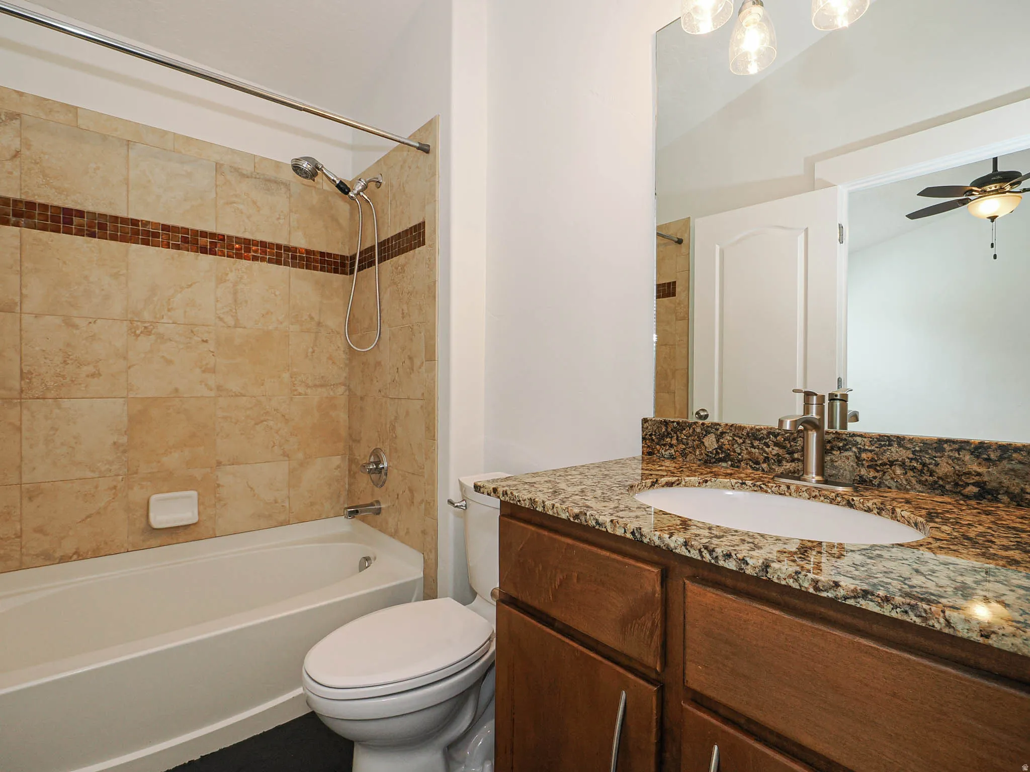 Full bath with vanity, shower / washtub combination, and a ceiling fan