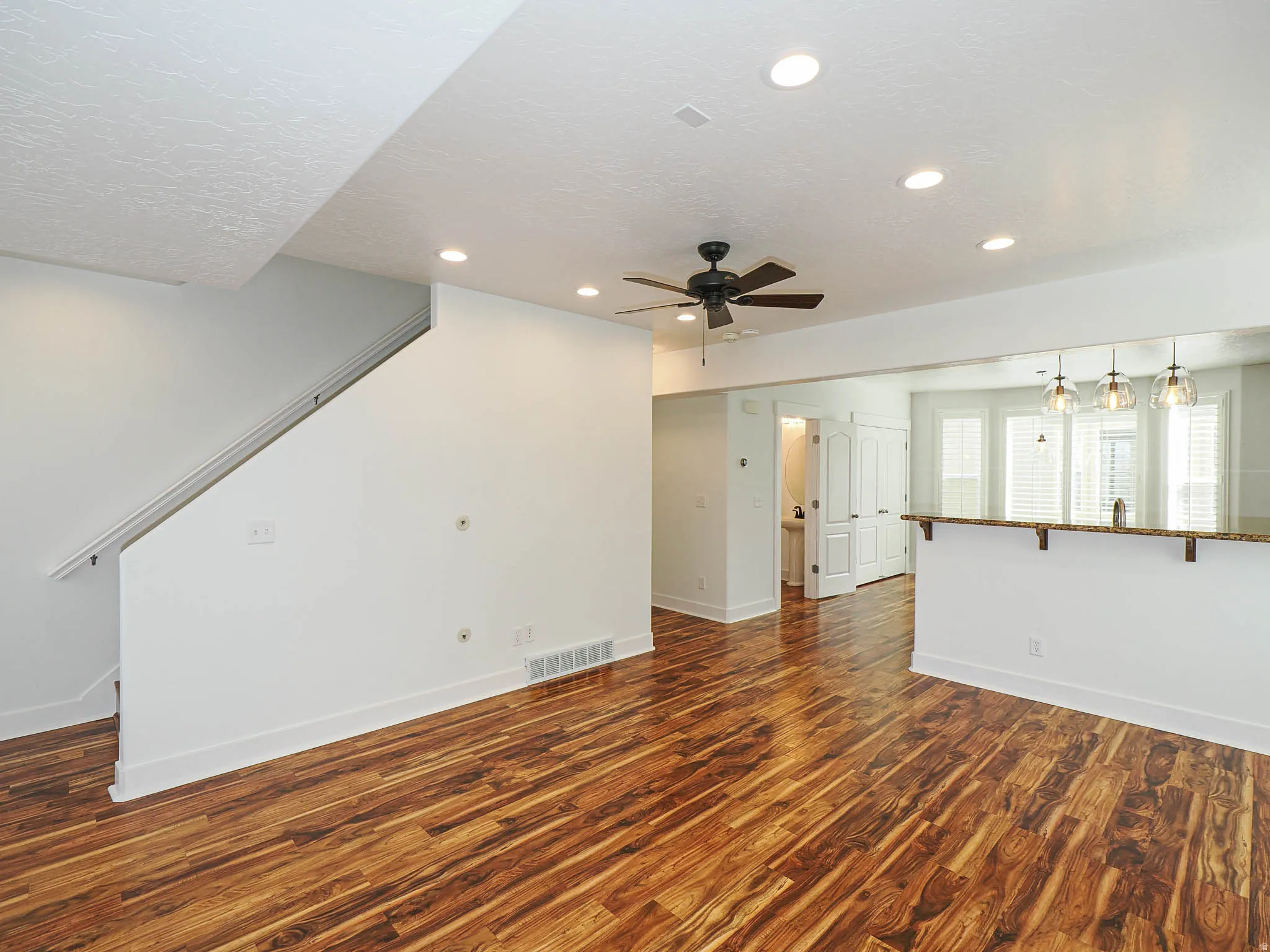 Unfurnished living room with dark wood-style flooring, recessed lighting, ceiling fan, and a textured ceiling