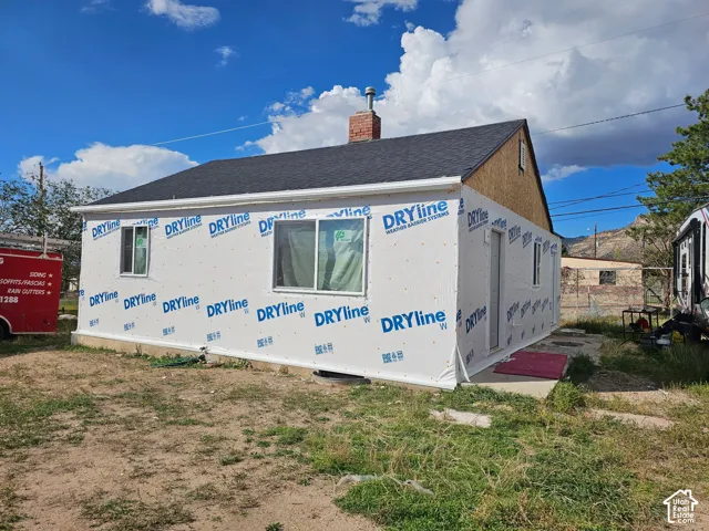 New construction featuring exterior weather barrier system, new windows, and asphalt shingle roofing