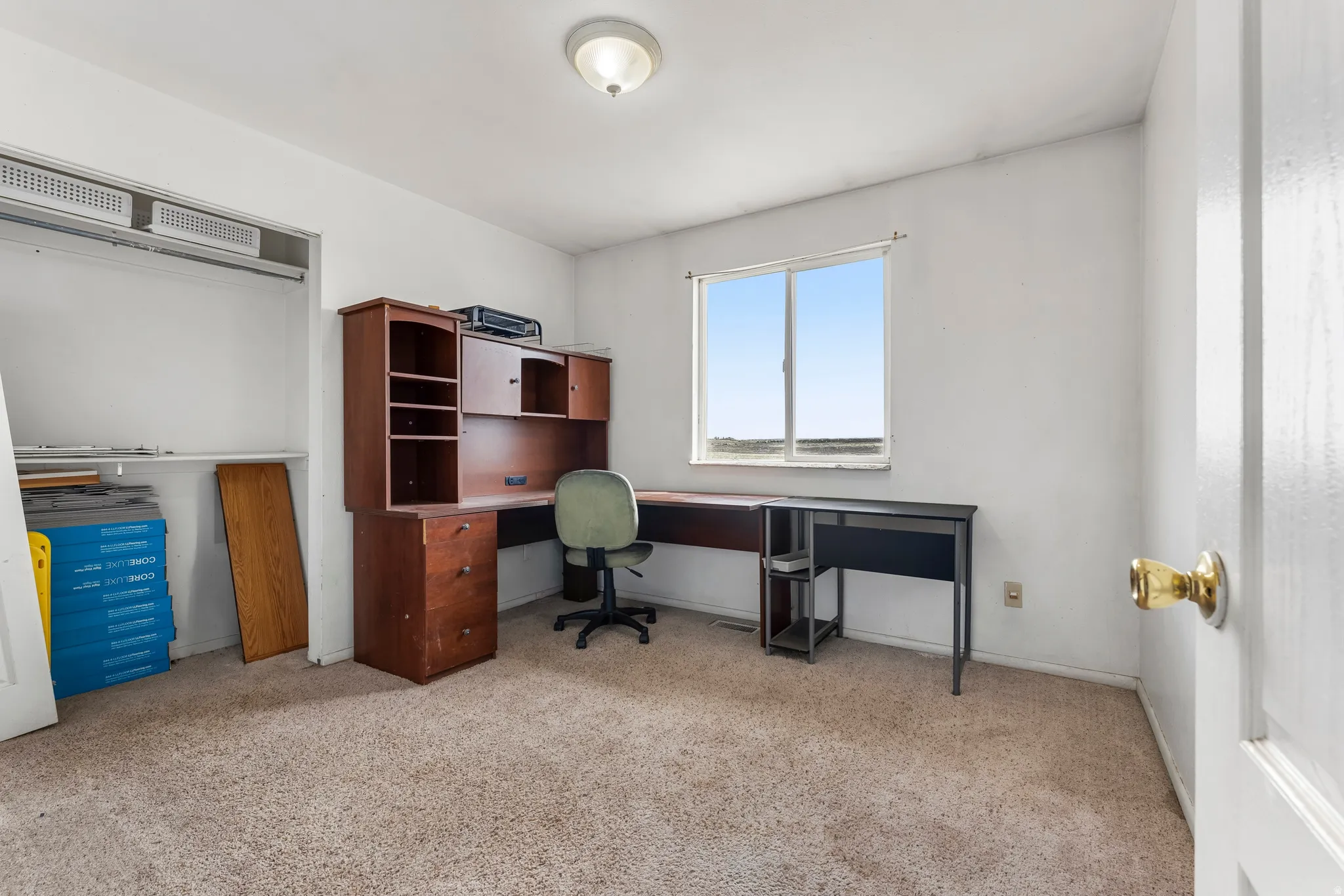 Office space with light colored carpet and baseboards